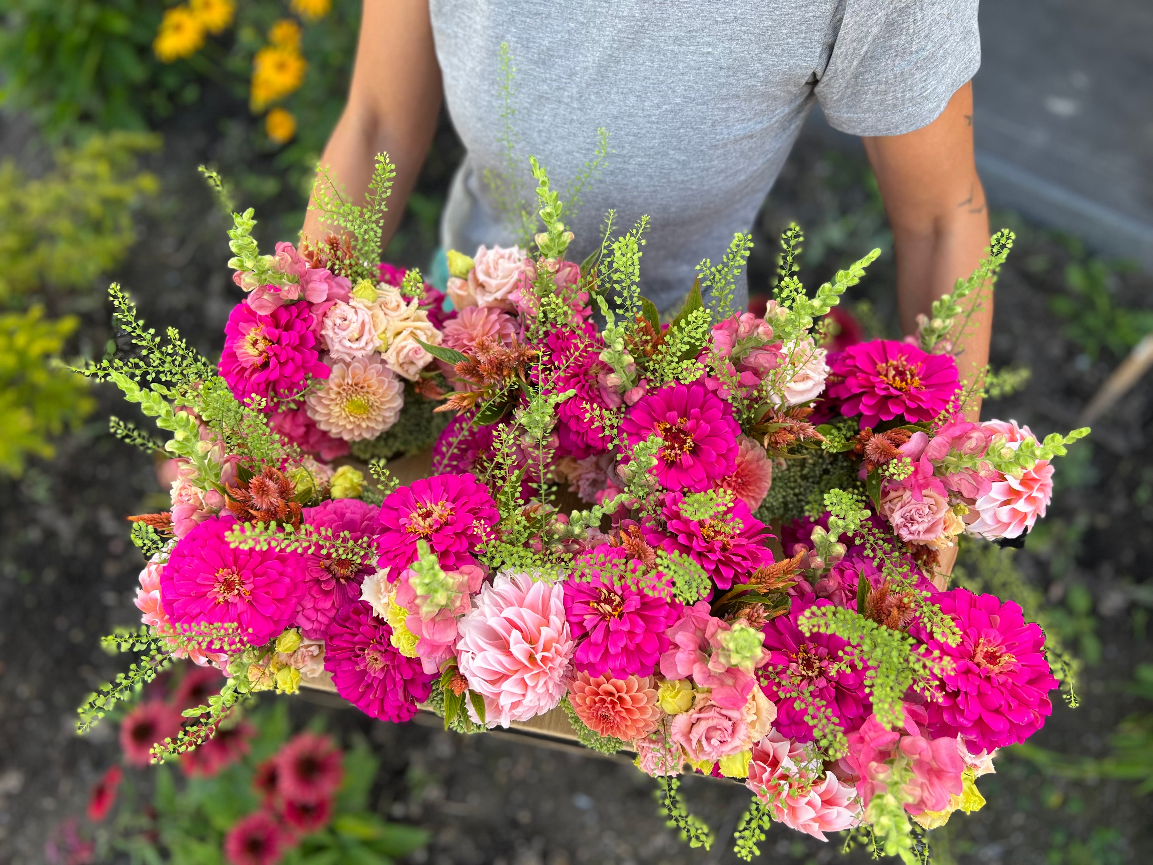 A display of eight mason jar arrangements in bright, summer colours.