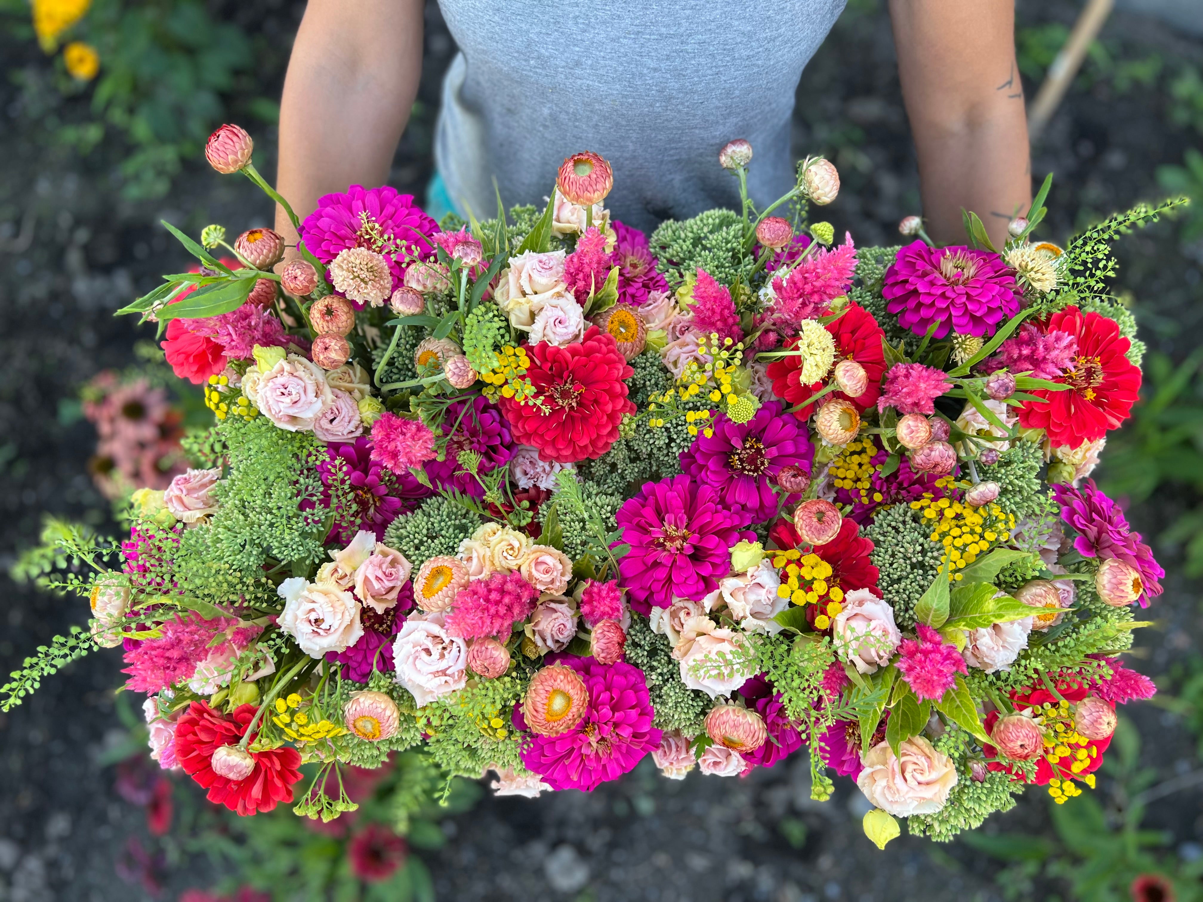 A display of eight mason jar arrangements in bright, summer colours.