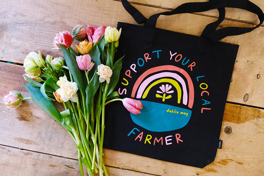 Black canvas bag with rainbow and support your local farmer in lettering around the rainbow.