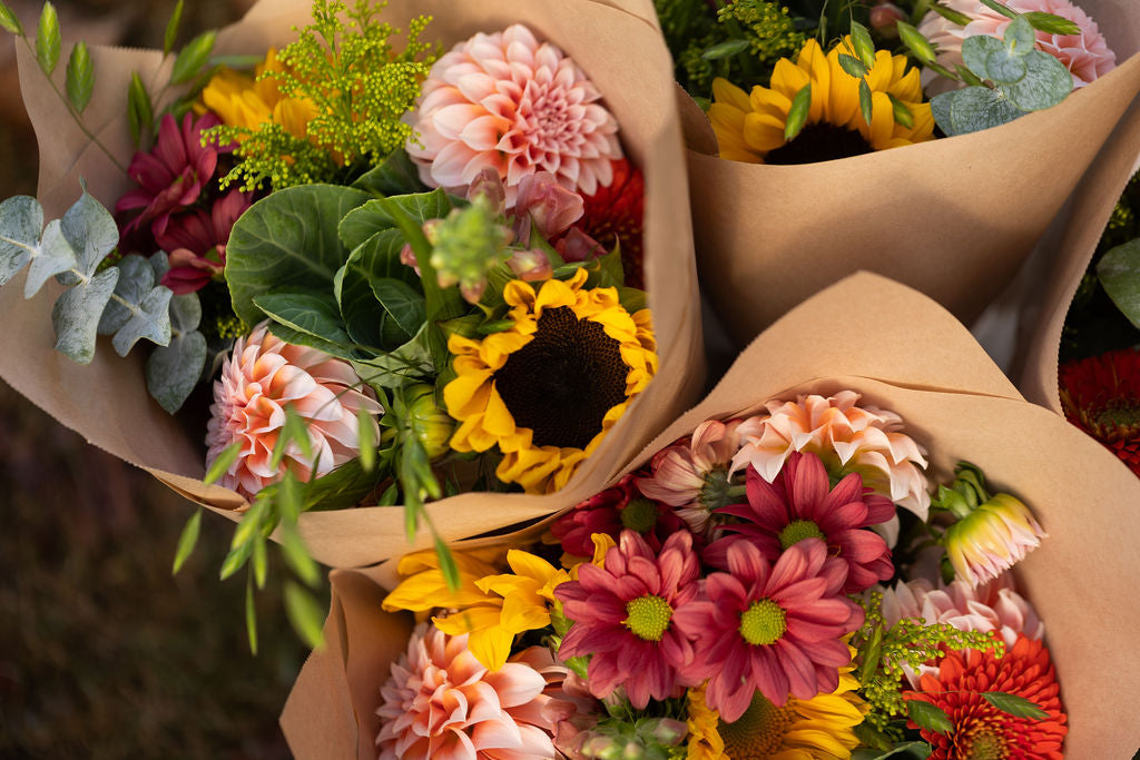 Fall coloured bouquets including sunflowers, ornamental cabbage, eucalyptus, dahlias and mums.
