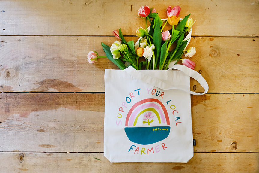 Off-white canvas bag with rainbow logo and 'support your local farmer' around the rainbow.