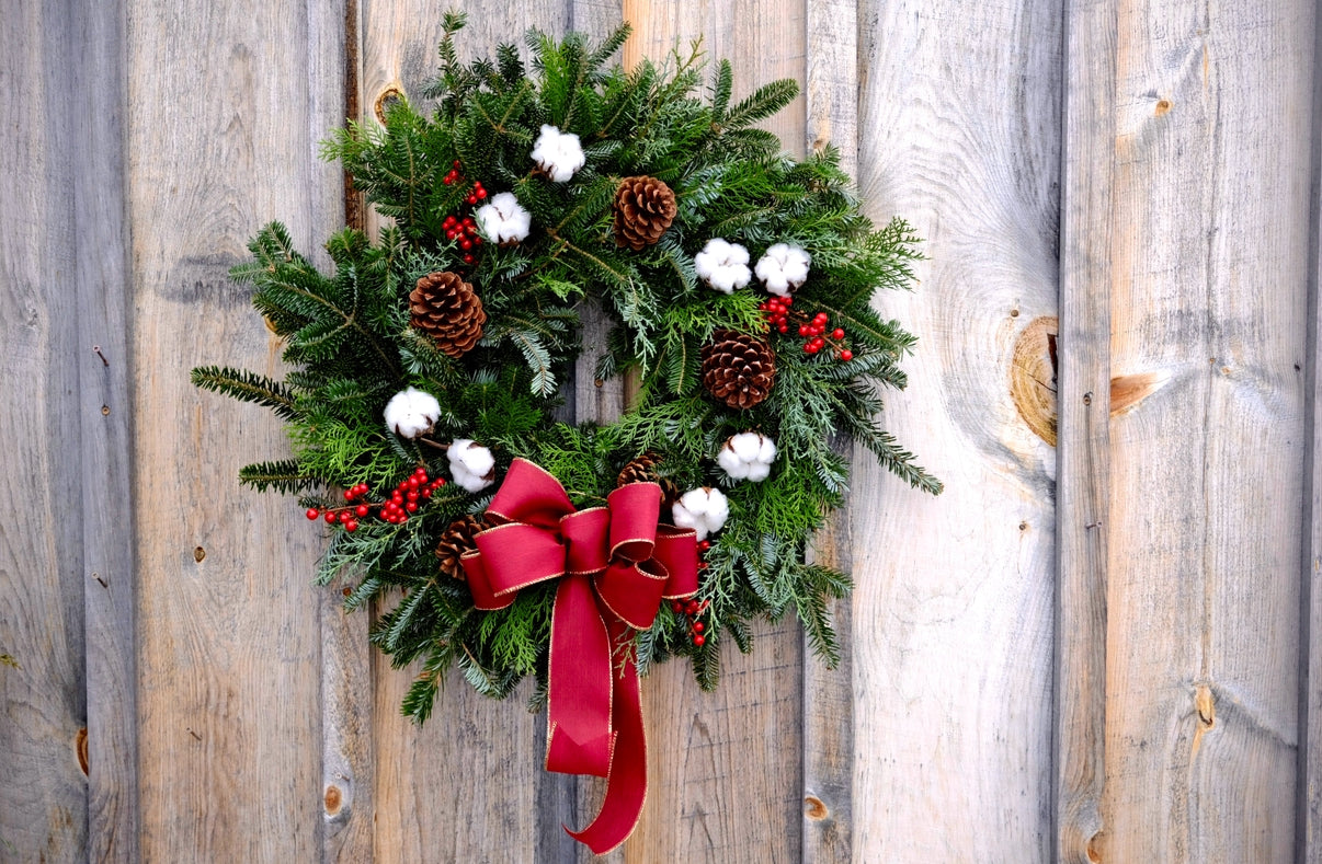 Christmas wreath with red bow on a wooden door