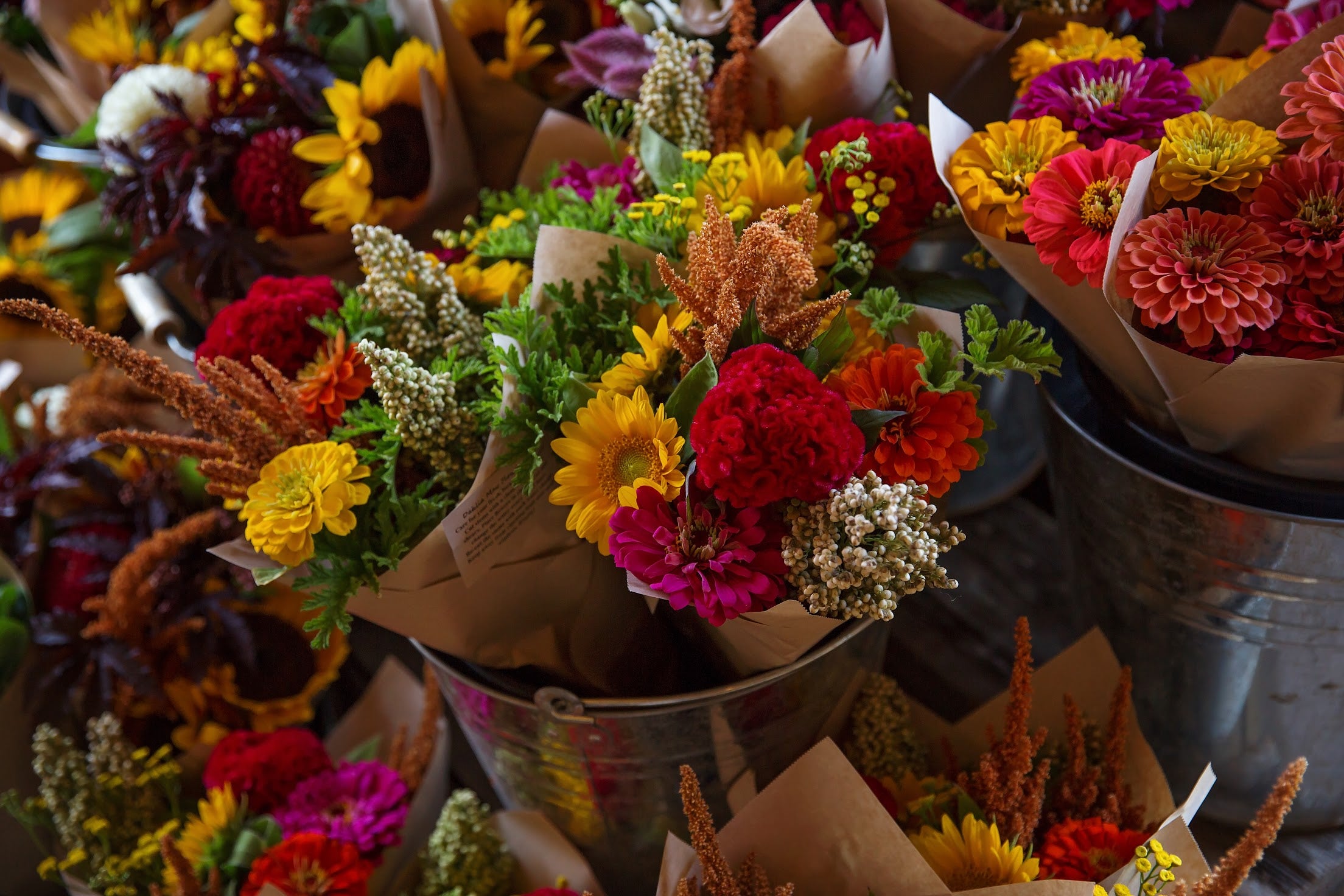 Bouquets of mixed flowers in reds, yellows, pinks and purples.